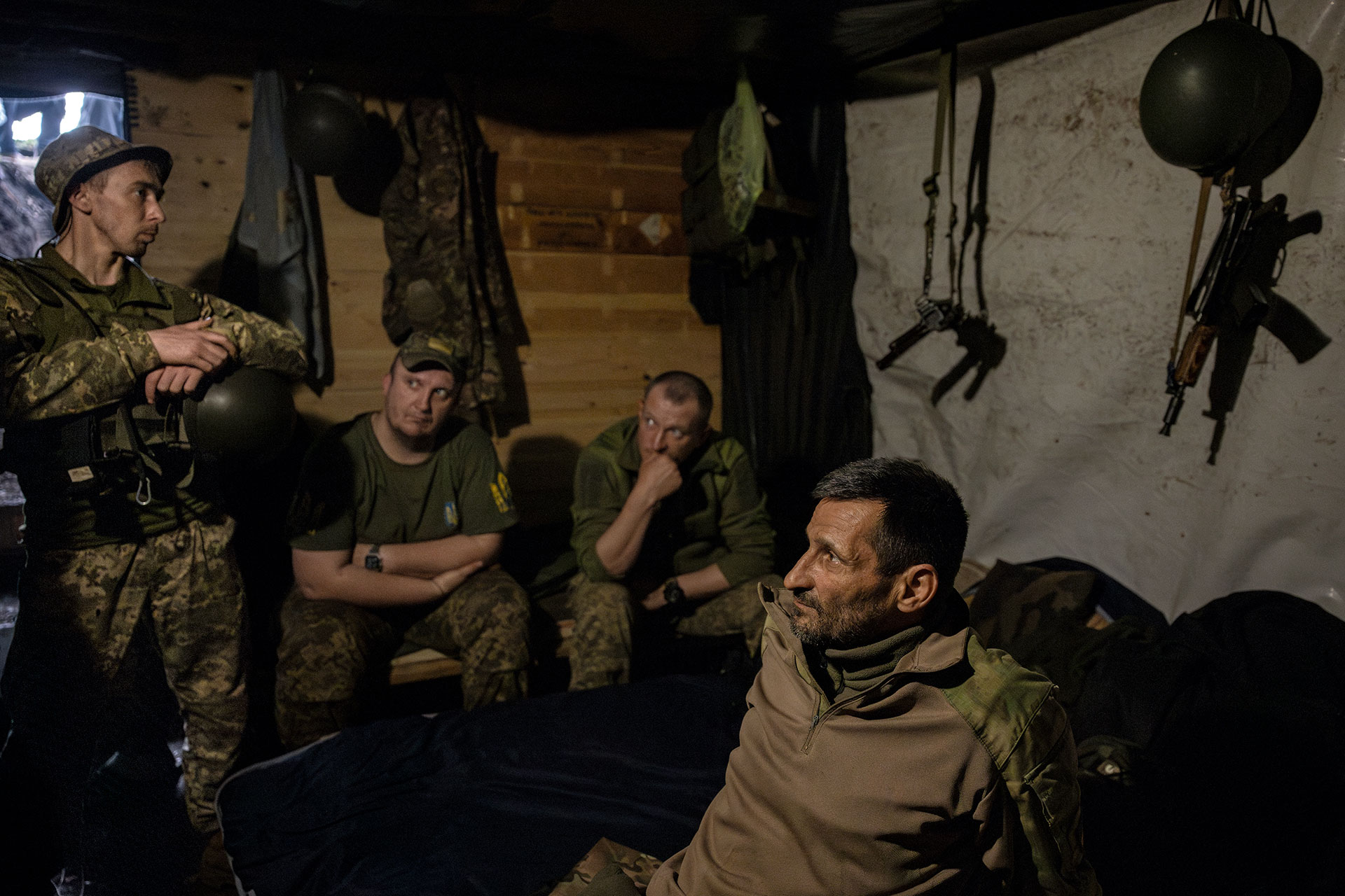 Командир артилерійської частини Юрій (праворуч) чекає зі своєю командою на вогонь у бліндажі біля лінії фронту. 